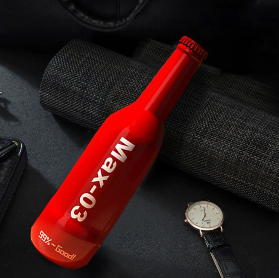 Beer bottle-shaped masturbator lifestyle photo — red bottle disguised airplane cup placed on desk for discreet storage
